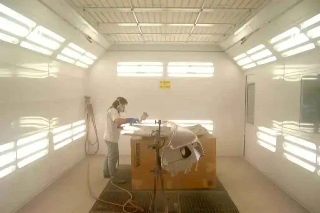 Painting an auto body part inside the paint booth at McCarthy's Auto Body - Cleveland OH